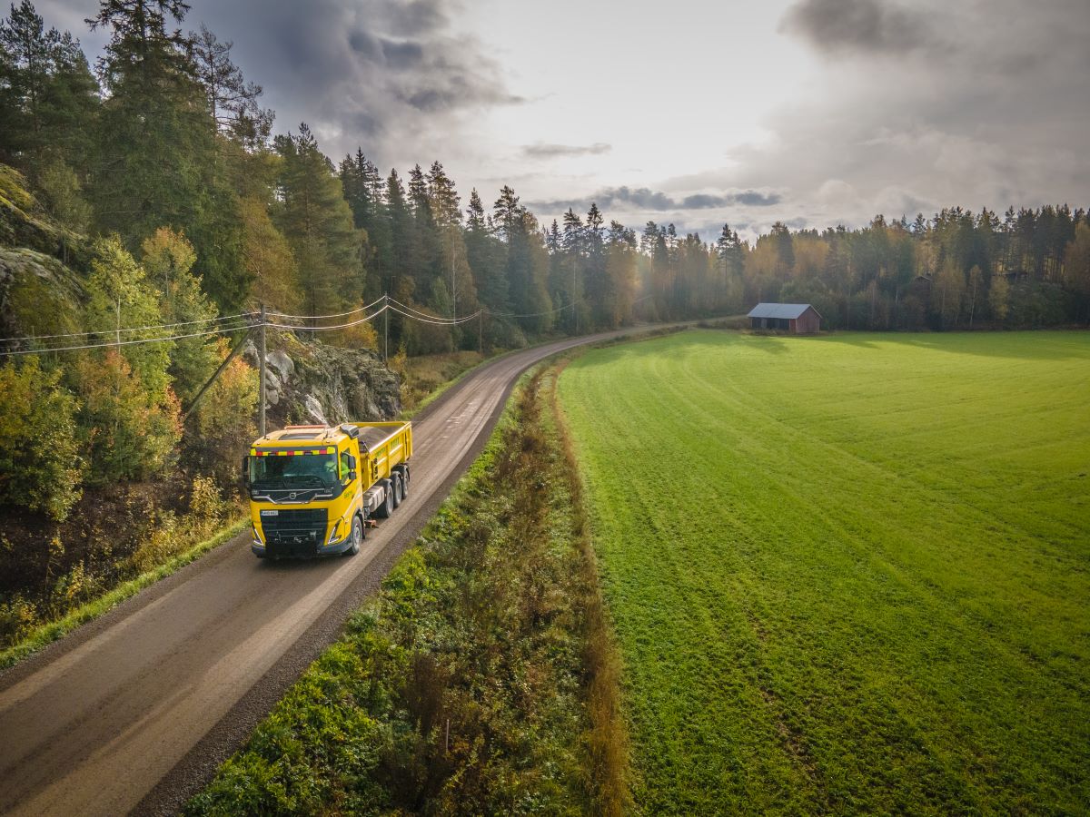 Camion sur une route de campagne entourée de forêts et de champs