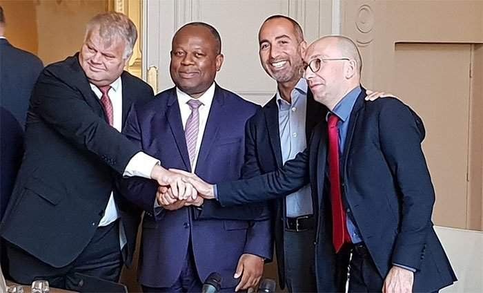 Quatre hommes en costume qui se serrent la main